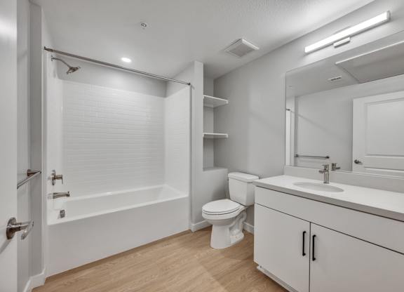 A white bathroom with a toilet, sink, and bathtub.