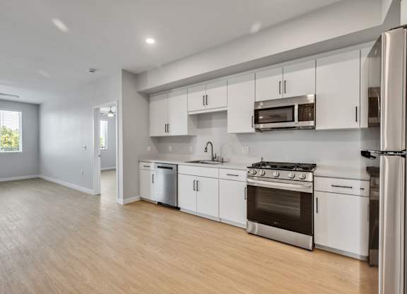 A modern kitchen with white cabinets and stainless steel appliances.