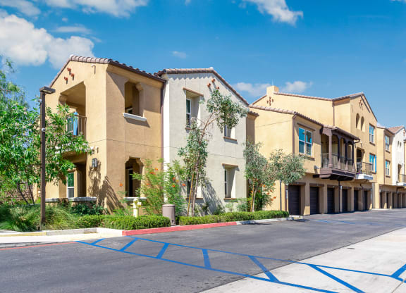 a row of apartment buildings with blue parking mats in front of them