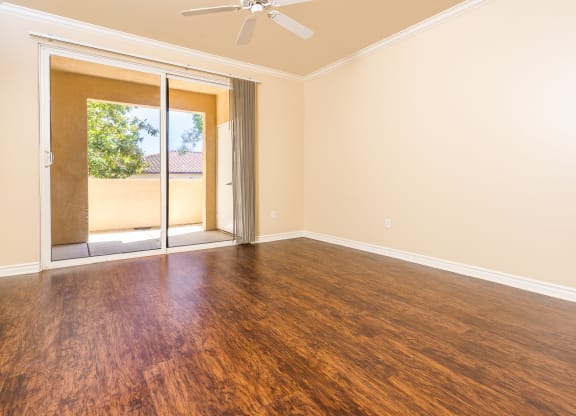 a living room with hardwood floors and a sliding glass door to a patio