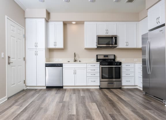 a kitchen with white cabinets and stainless steel appliances