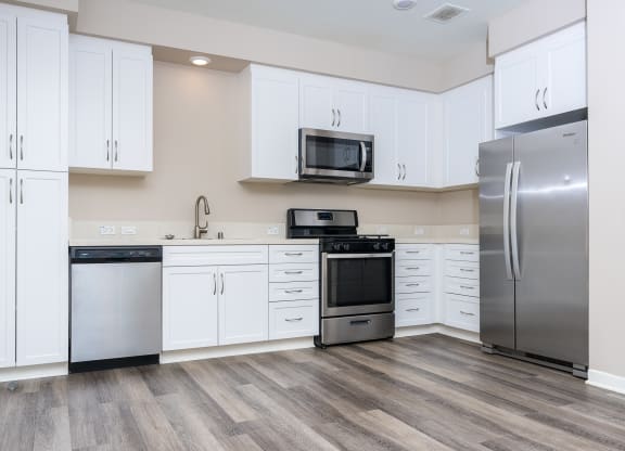a kitchen with white cabinets and stainless steel appliances