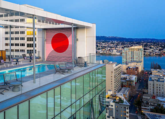 A modern building with a pool and a red circle on the side.