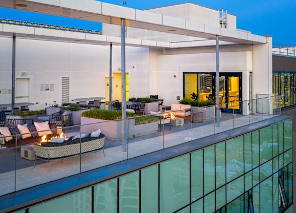 A modern house with a glass balcony and a fire pit.