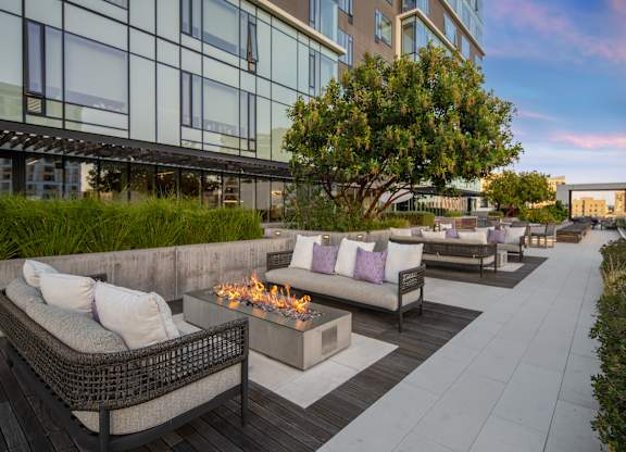 A patio with a fire pit and couches.