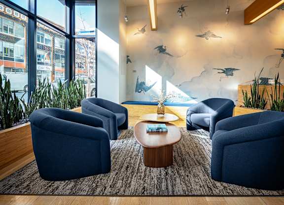 A room with blue chairs and a table with a tray on it.