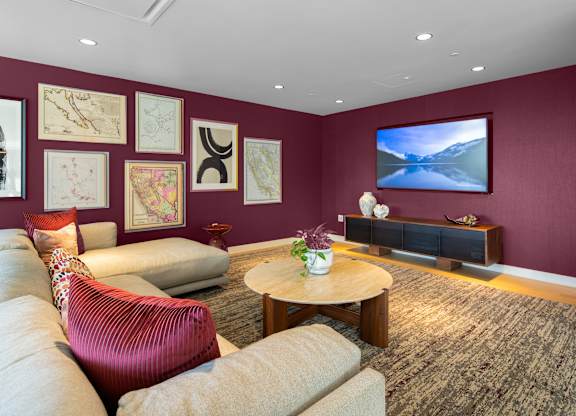 A living room with a red chair and a television.