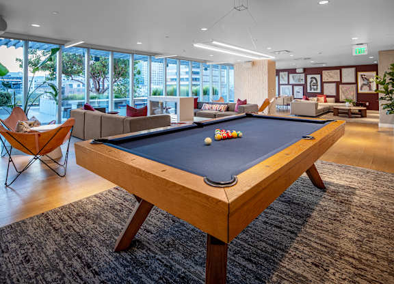 A pool table in a room with a view of the city.