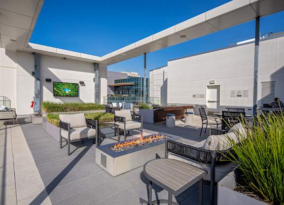 A patio with a fire pit and seating area.
