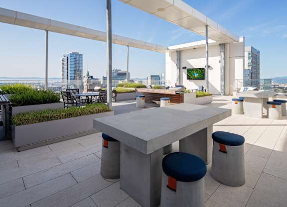 A white table with blue seats is in the middle of a patio.