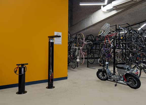 A yellow wall with a bike rack full of bicycles.