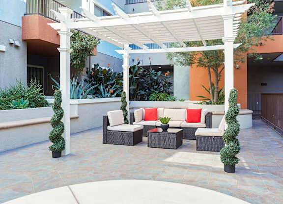 A patio with a white pergola and a couch.at 6940 Sepulveda, Van Nuys, 91405  