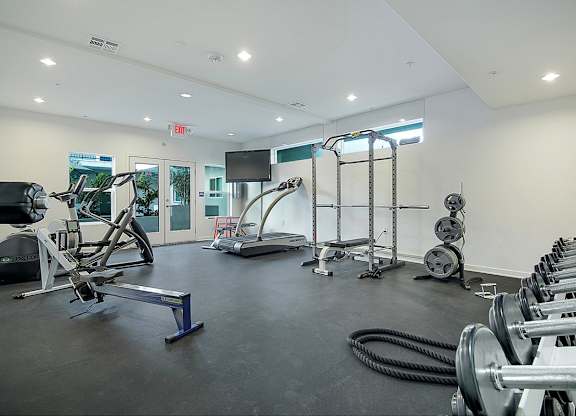 A gym with a variety of equipment including treadmills, weights, and exercise machines.at Grand View Towers, Los Angeles, CA  