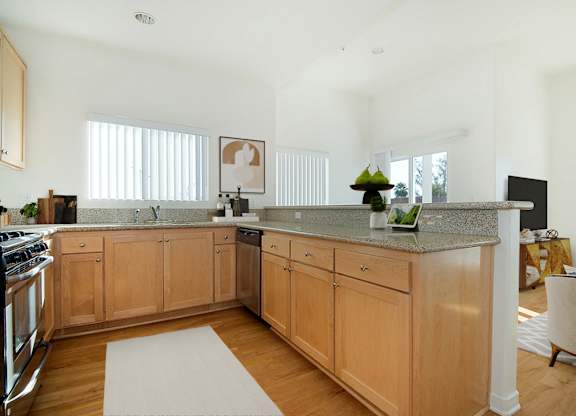 A kitchen with wooden cabinets and a granite countertop.at Grand View Towers, Los Angeles  
