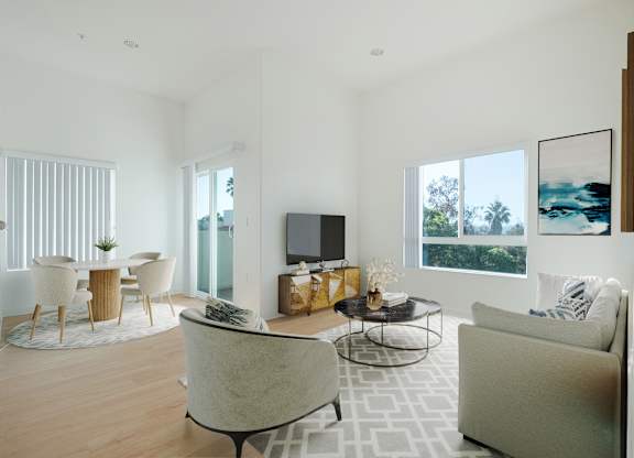 A modern living room with a large couch, a chair, a coffee table, and a television.at Grand View Towers, Los Angeles California  
