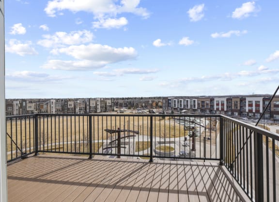 a balcony with a view of a playground and a city at Parkside at Littleton Village, Colorado