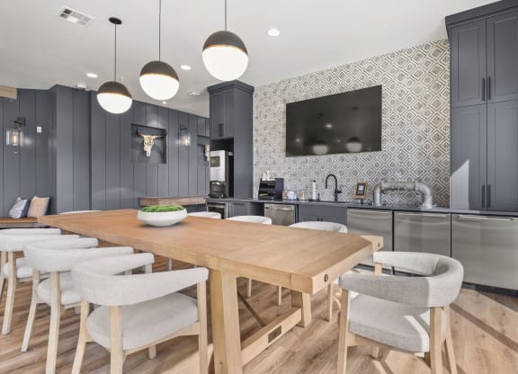 a dining area with a wooden table and chairs and a kitchen with gray cabinets at Parkside at Littleton Village, Littleton, 80122