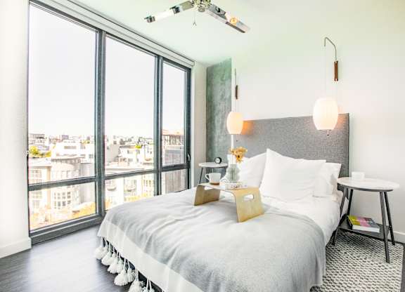 A bedroom with a large bed and a view of the city.at The Rise, California  