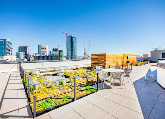 A rooftop patio with a table and chairs overlooking a city skyline.at The Rise, San Francisco, CA 94103  