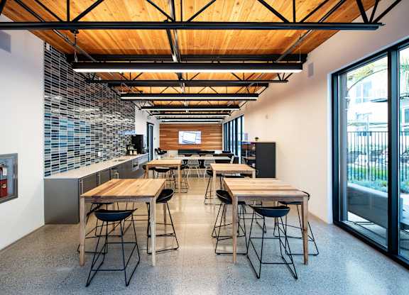 A modern kitchen with a long table and chairs.