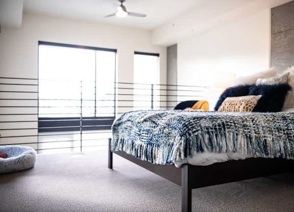 A bedroom with a bed, pillows, and a blanket.