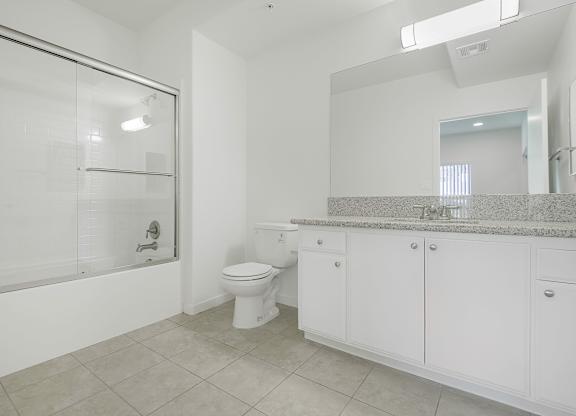 A white bathroom with a toilet, sink, and bathtub.