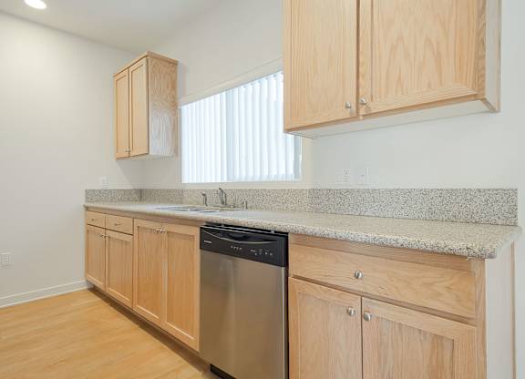 A kitchen with wooden cabinets and a granite countertop.
