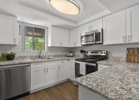 a kitchen with granite counter tops and white cabinets at Vaseo Apartments, Phoenix, 85022