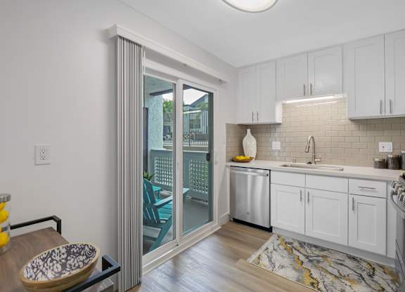 A kitchen with white cabinets and a marble floor at Verandas Apartments, California, 91791