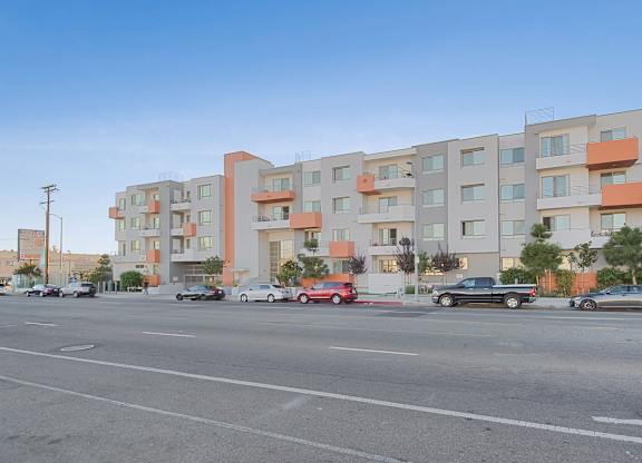 A street view of a residential area with cars parked and driving at Woodley Sara Apartment, California, 91406