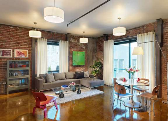 A living room with a couch, chairs, and a dining table.