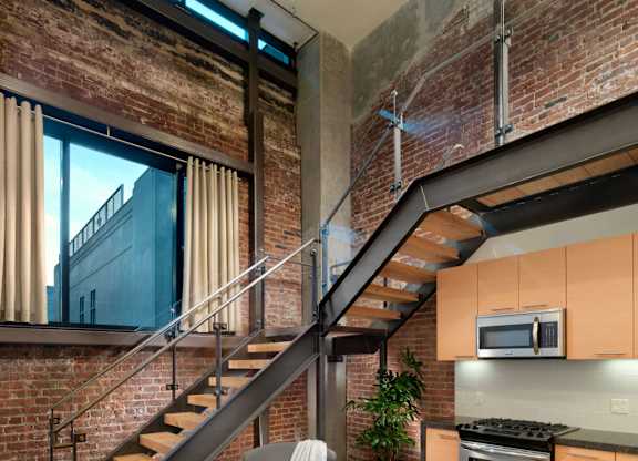 A modern kitchen with a staircase leading to the upper floor.