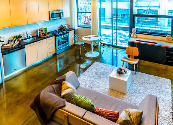 A modern kitchen with a refrigerator, microwave, oven, and sink.
