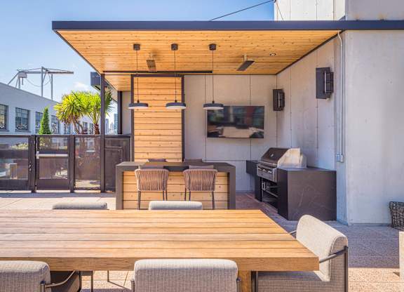 A wooden table is surrounded by chairs on a patio.