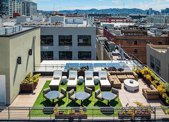 A rooftop patio with a pool and furniture.
