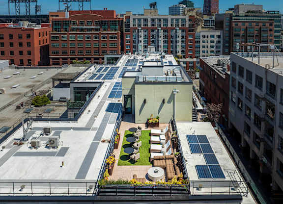 A rooftop garden with a seating area and solar panels.
