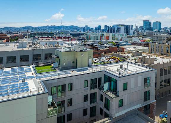 A cityscape with buildings and solar panels on the roofs.