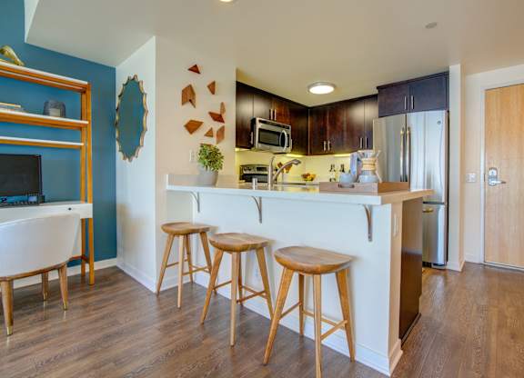 Kitchen with a white counter and wooden stools at Towers at Rincon, San Francisco, CA