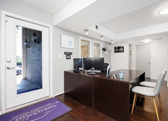 A reception area with a desk and a chair.