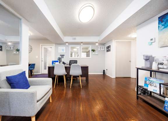 A living room with a grey couch and a wooden floor.