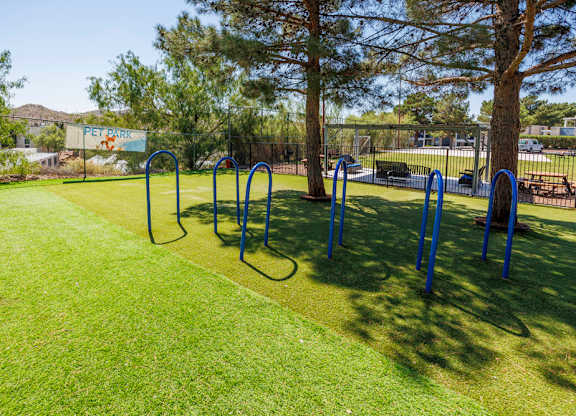 A park with a grassy area and exercise equipment.