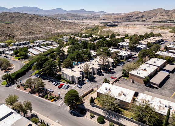 A view of a parking lot with cars and buildings.
