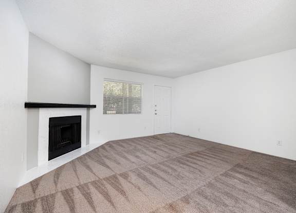 A room with a fireplace and carpeted floor.