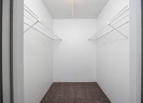 A walk-in closet with white walls and shelves.