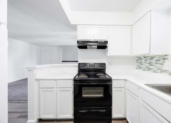 A black oven in a white kitchen.