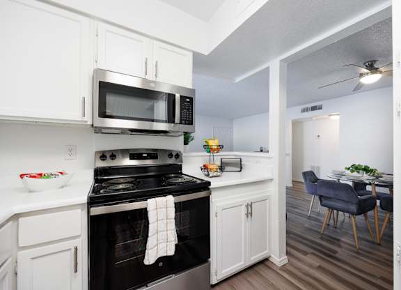 A kitchen with a stove, microwave, and oven.