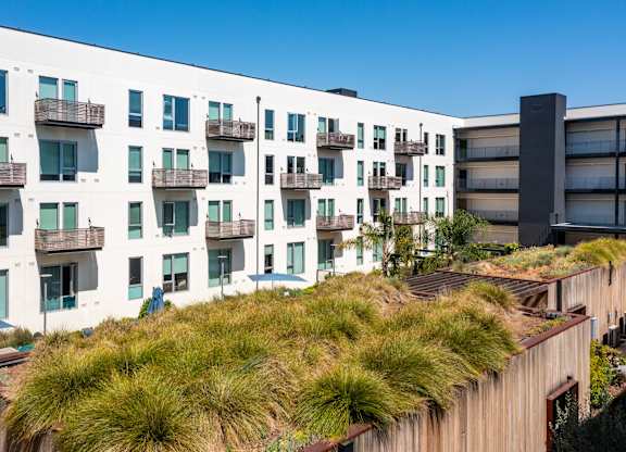 A modern building with a green roof and balconies.