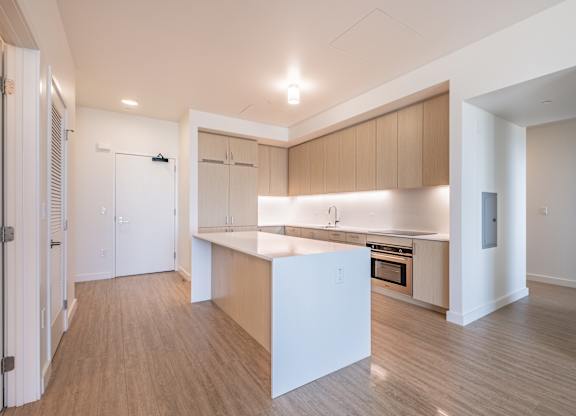 A kitchen with a white island and wooden floors.