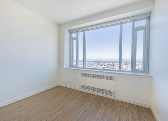 A room with a window overlooking a cityscape.