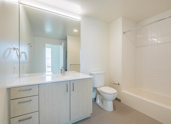 A white bathroom with a toilet, sink, and bathtub.